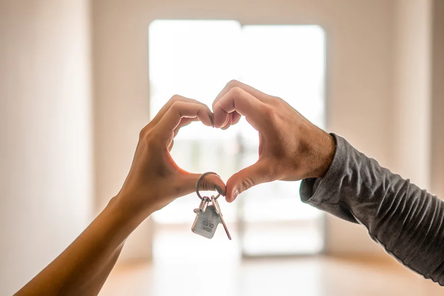 Casal feliz com mãos em formato de coração, pois investiram num apartamento garden na Silvio Iwata
