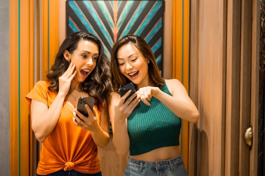 Mulheres pesquisando em celular apartamento na planta