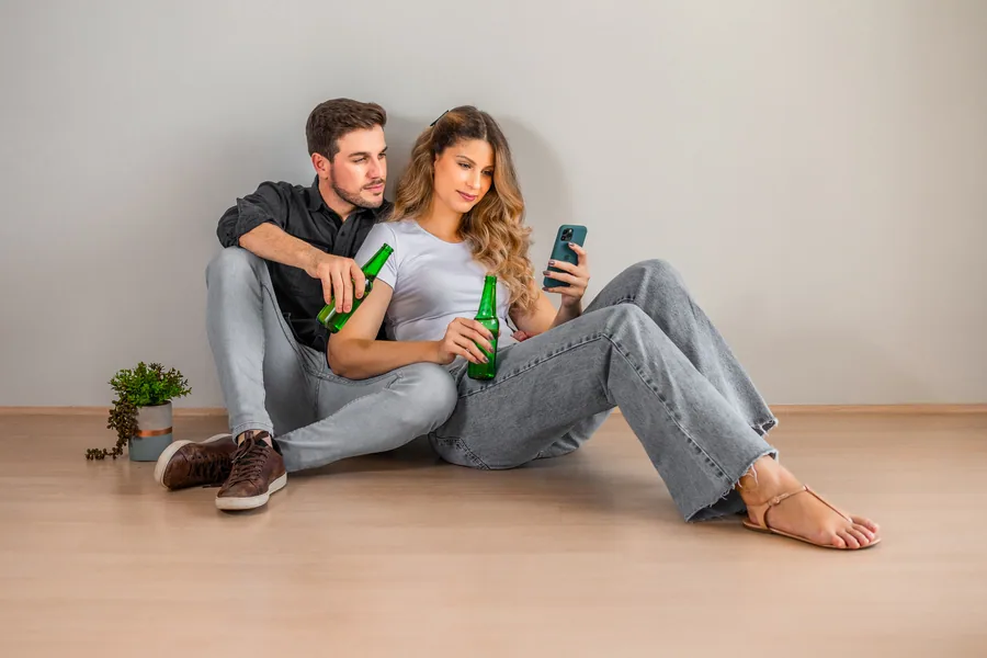 Casal tomando uma cerveja lendo sobre casa de veraneio no Paraná