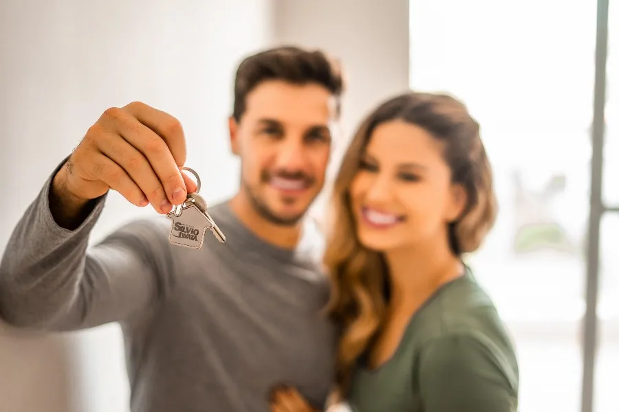 Casal com chave de apartamento simbolizando garantia de aluguel 