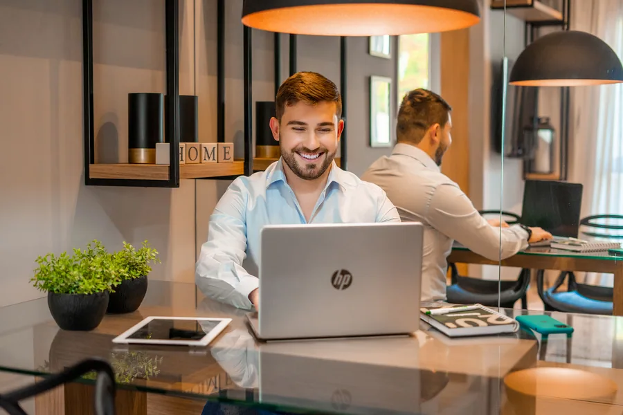 Jovem feliz lendo sobre multipropriedade e vendo que é um ótimo investimento