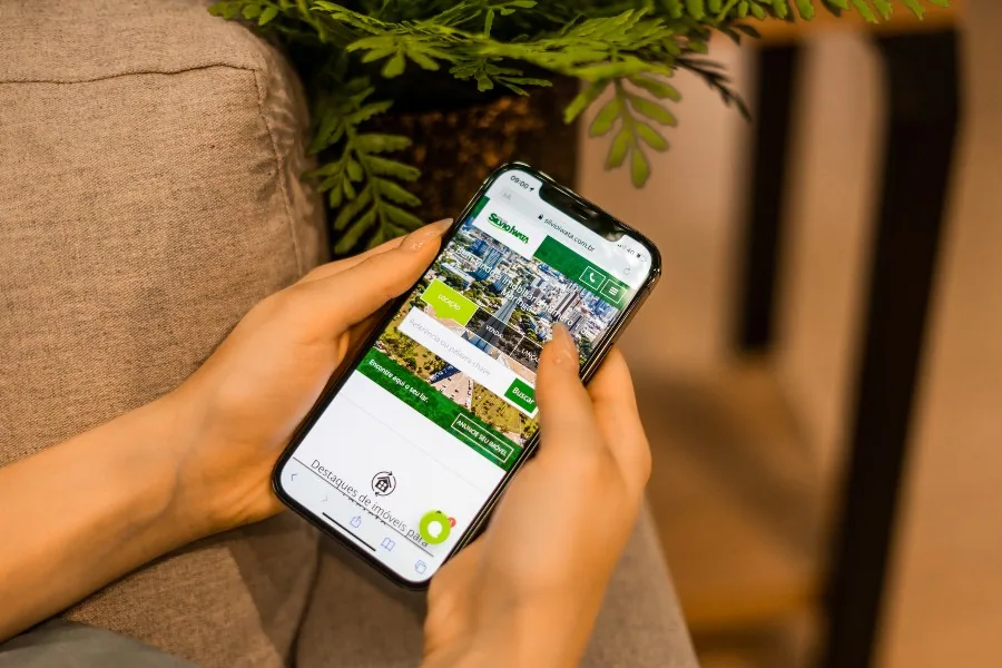 pessoa mexendo no site da Silvio Iwata pelo celular ao pensar quero alugar meu apartamento