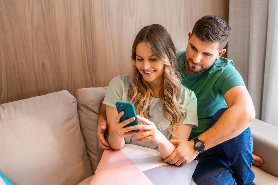 Casal lendo sobre valorização de imóvel no celular.